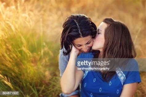 lesbian woman kissing her partners cheek while outside photo getty images