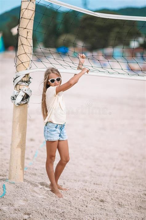 little adorable girl playing voleyball on beach with ball stock image