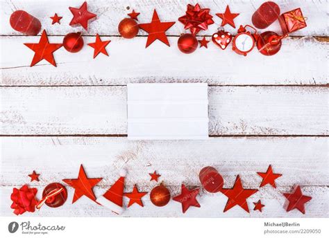 rahmen aus roten weihnachts ornamenten auf weissem tisch ein
