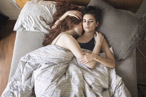 High Angle Portrait Of Lesbian With Girlfriend Relaxing On Bed At Home