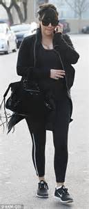 kim kardashian hides her figure under two jackets as she