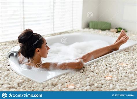 Pretty Millennial Woman Lying In Bathtub With Foam Enjoying Bubble