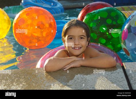 Girl In Swimming Pool With Assortment Of Beach Balls Portrait Stock