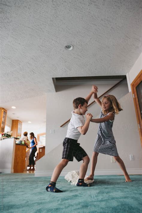 brother and sister play fighting inside by stocksy contributor rob