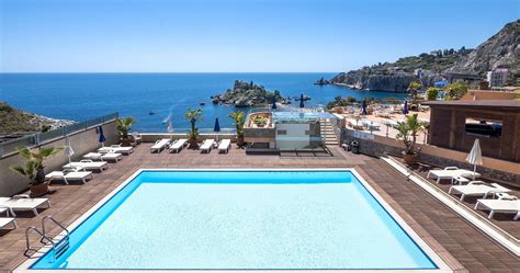 outdoor swimming pool  chaise lounges overlooking  ocean  rocky cliff sides