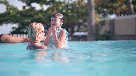 Mom And Daughter Playing Together Diving Underwater In Swimming Pool