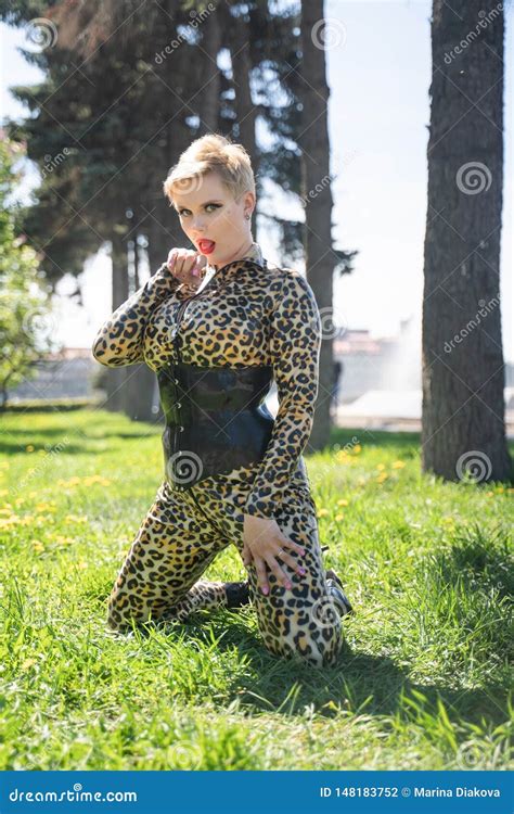 Curvy Blonde Woman With Short Hair Wearing Latex Rubber Catsuit And