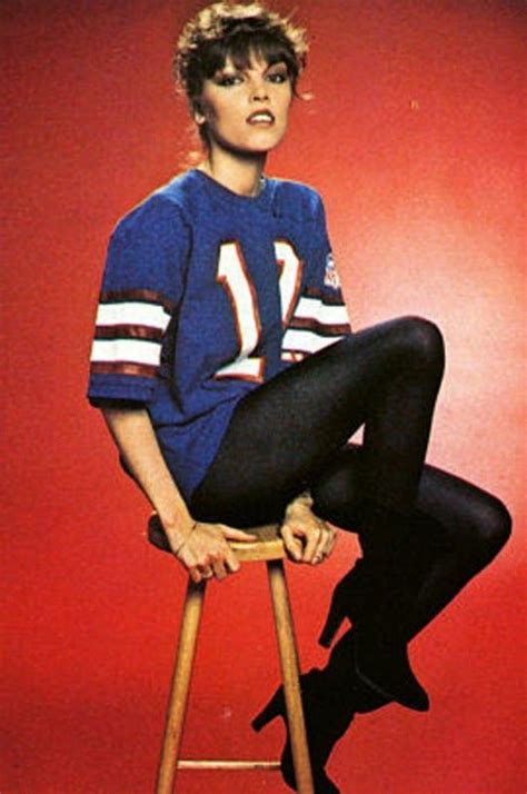 woman sitting  top   wooden stool wearing  football jersey