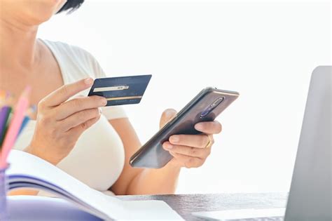 de creditcard van het vrouwengebruik voor  het winkelen op slimme telefoon en laptop