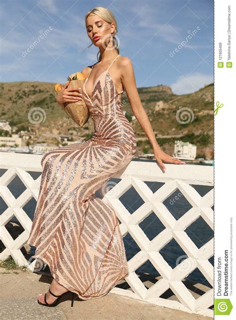 Beautiful Woman With Blond Hair In Luxurious Golden Dress