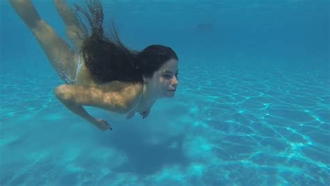 Amazing Slim Girl In A White Bikini Swimming Under Clear Water Stock