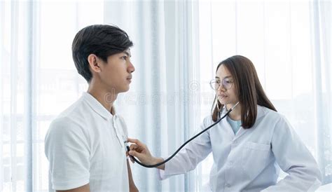 Female Doctor Examining The Health Of Male Patients Chest With A