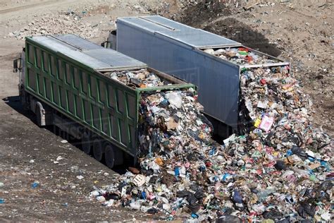 trucks dumping waste  landfill stock photo dissolve