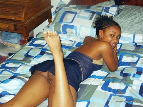 black bimbo in short blue dress seductively posing on the bed and flashing white panty picture 7