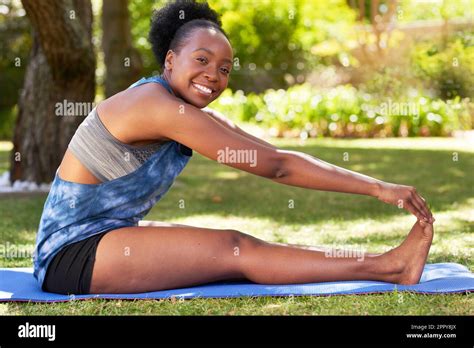 Young Black Woman Reaches To Feet In Big Stretch Outdoors Yoga Park