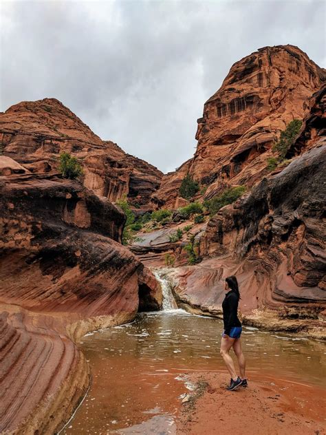 man standing   middle   river surrounded  red rocks