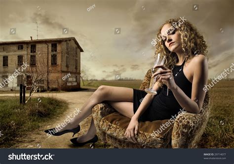 Girl Sitting On Armchair With Glass Of Wine In The
