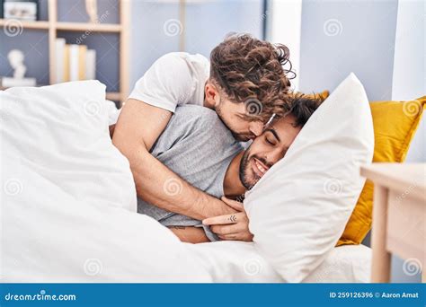 Young Couple Hugging Each Other And Kissing Lying On Bed At Bedrooom