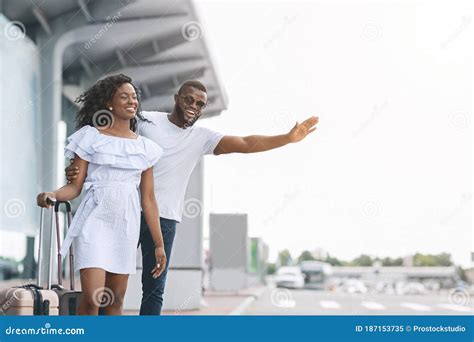 catching cab happy black couple standing  airport parking calling taxi stock image image