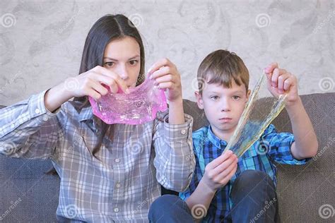 Mom And Son Are Playing With Slime Sitting On The Sofa Stretching