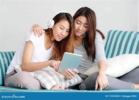Young Cute Asia Lesbian Couple Using Tablet With Happiness Free