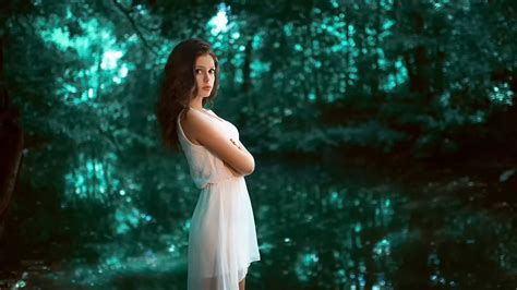 Beautiful Girl Model Is Wearing White Dress Standing In Blur Forest