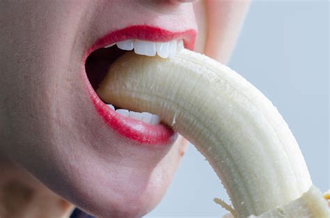 nahaufnahme der frau beißen banane suggestively stockfoto und mehr