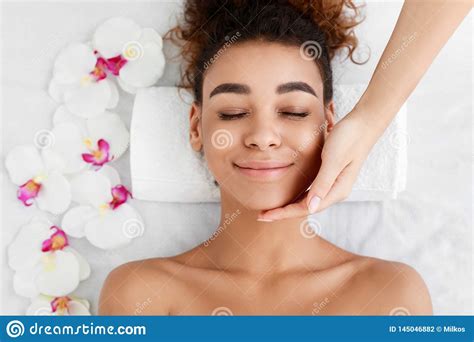African American Woman Getting Face Massage At Beauty