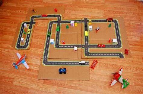 cardboard race track  toy cars  planes   wooden floor