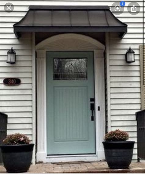 blue front door   black planters   steps   white house