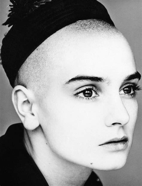 A Black And White Photo Of A Woman With Shaved Hair