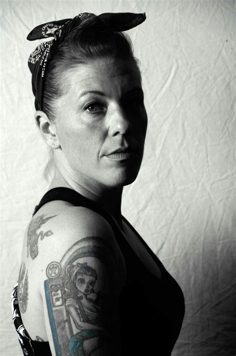 a woman with tattoos on her arm posing for the camera