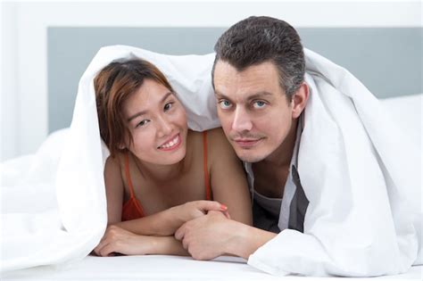 Free Photo Smiling Couple Covered With Blanket In Bed