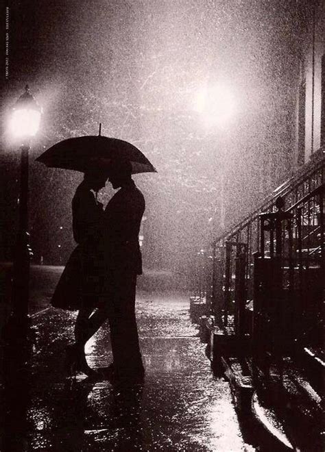 Silhouette Of A Couple Embracing Under An Umbrella In The Rain Kissing