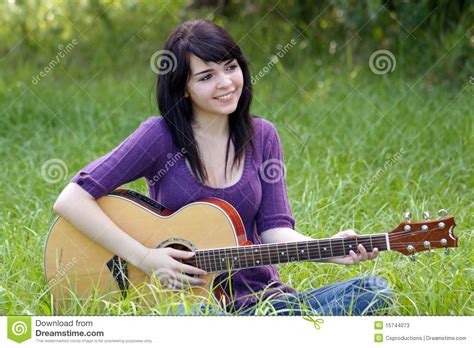 beautiful brunette outdoors with a guitar 1 stock image