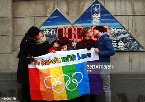 a group of gay and lesbian activists hold a banner of the rainbow