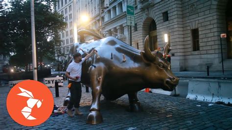 protest artist covers wall street bull in dildos rides it