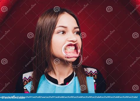 close up of female mouth with retractor doctor flossing the teeth