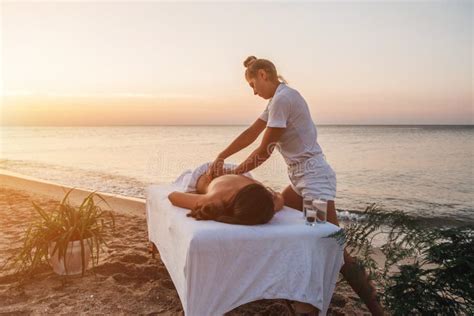 Young Masseuse Doing Massage By The Sea At Sunrise Stock Image Image