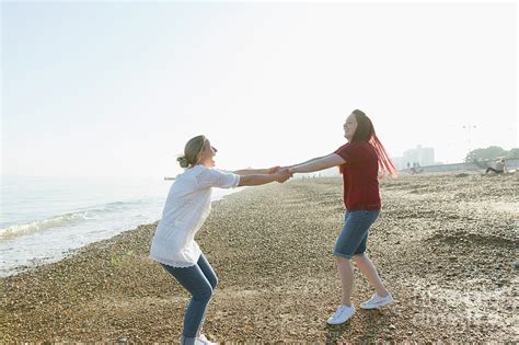 Playful Lesbian Couple Holding Hands And Spinning Photograph By Caia