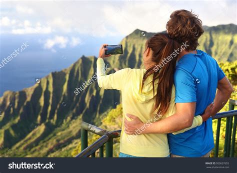 happy interracial travel couple taking selfie picture with