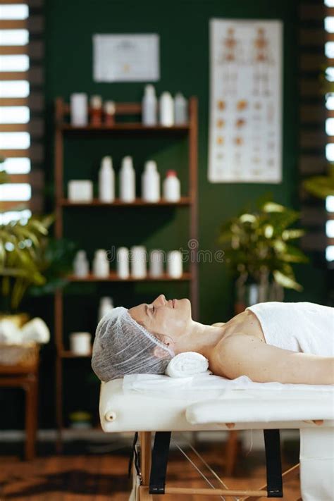Relaxed Modern Female In Spa Salon Laying On Massage Table Stock Image