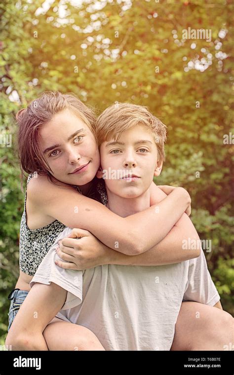 portrait teenage boy carrying sister  res stock photography