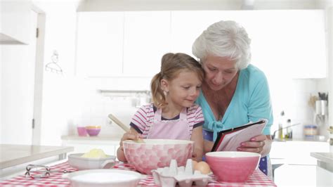 Grandmother And Granddaughter Baking In Kitchen Stock Video Footage