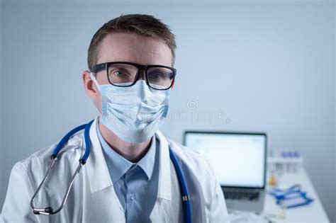 Tired Young Doctor Takes Off Glasses And Protective Medical Mask