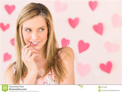 Woman Biting Lip With Heart Shaped Papers Against Colored
