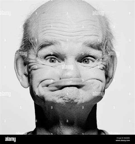 A Monochrome Picture Of An Old Man With No Teeth With His Bottom Lip
