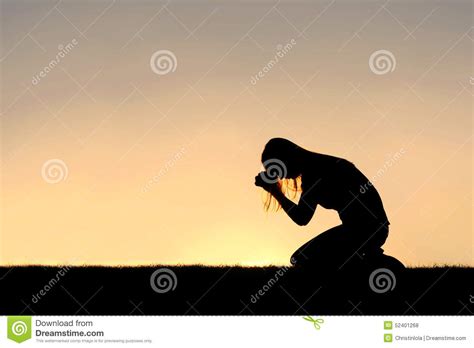 christian woman sitting down na silhueta da oração foto de