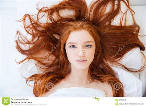 Woman With Beautiful Long Red Hair Lying In Bed Stock