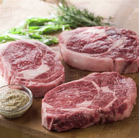 raw ribeye steaks stock photo dissolve